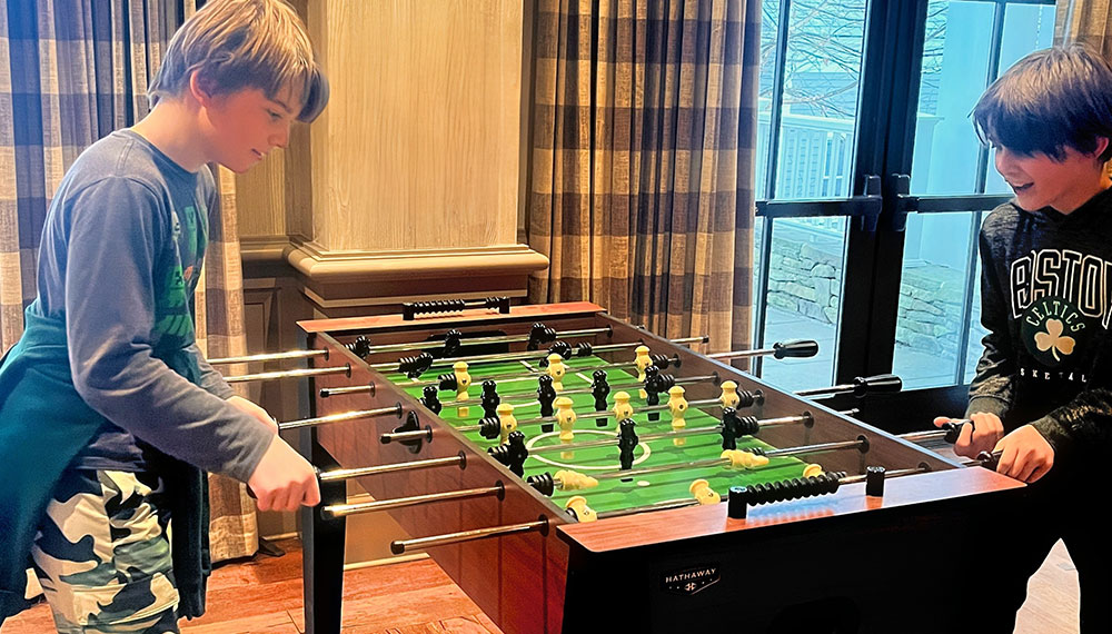 2 boys playing foosball at kimpton taconic hotel